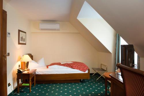 a bedroom with a bed in a attic at Hotel Schloss Schkopau in Schkopau