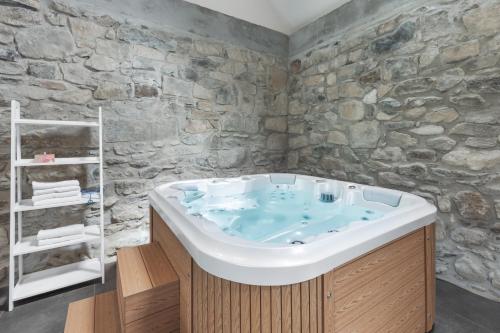 a bath tub in a bathroom with a stone wall at Koblitzer Hof in Liběšice