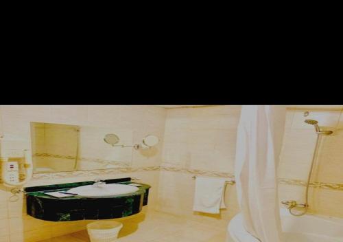 uma casa de banho com um lavatório, um WC e uma banheira em روتانة للشقق المخدومة بالحمرا em Jeddah