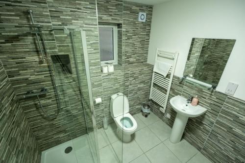Un baño con ducha, inodoro y lavabo. en Tobermory Apartment, en Oban