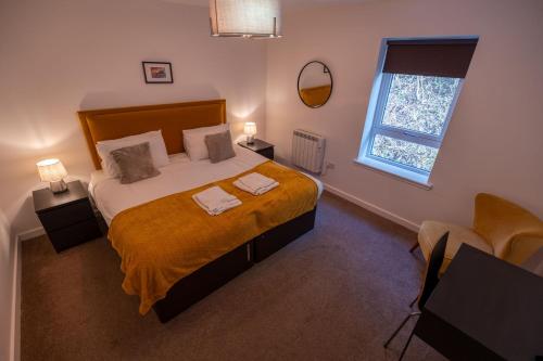 a bedroom with a large bed and a window at Tobermory Apartment in Oban