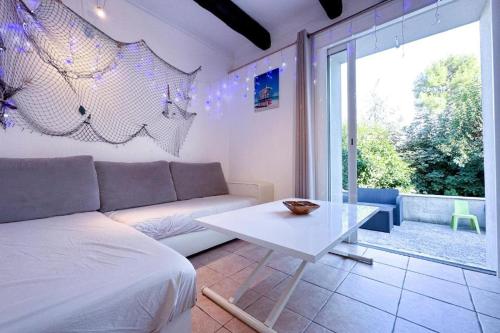 un salon avec un canapé blanc et une table dans l'établissement Appartement dans la villa 