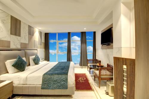 a hotel room with a bed and a large window at Hotel International Inn - Near Delhi Airport in New Delhi