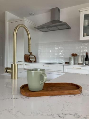 un comptoir de cuisine avec une tasse sur une planche de coupe en bois dans l'établissement St Malo à 15 Min et 10 Min de Dinard, à Pleurtuit