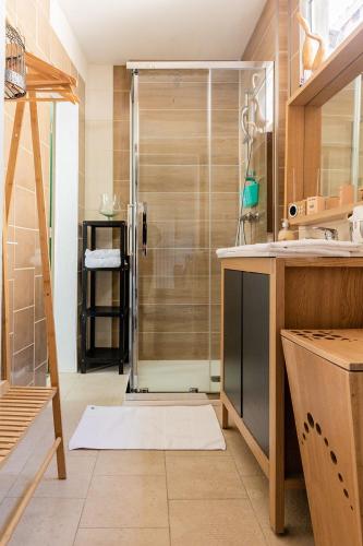 une salle de bain avec une douche avec une porte vitrée dans l'établissement Le Vintage, à Périgueux