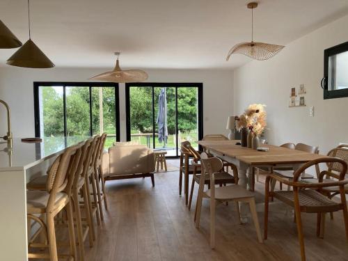 - une salle à manger avec une table et des chaises en bois dans l'établissement St Malo à 15 Min et 10 Min de Dinard, à Pleurtuit