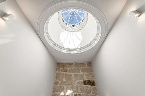 una ventana redonda en el techo de una habitación en Palácio Fenizia Lux Apartments, en Oporto