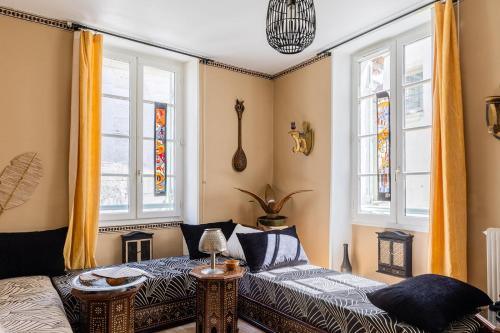 un salon avec un canapé et deux fenêtres dans l'établissement Le Vintage, à Périgueux