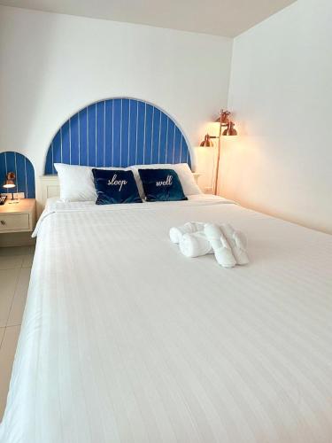 a large white bed with two towels on it at Costa Beach Residence & Jacuzzi in Sattahip