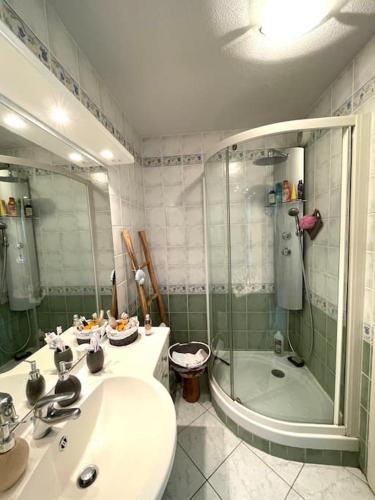 une salle de bain avec un lavabo et une douche dans l'établissement Appartement avec piscine proche de la mer, à La Londe-les-Maures