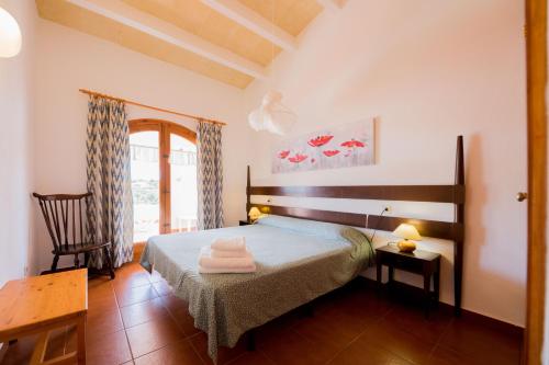 a bedroom with a bed with two towels on it at Villas Es Brucs in Cala Morell
