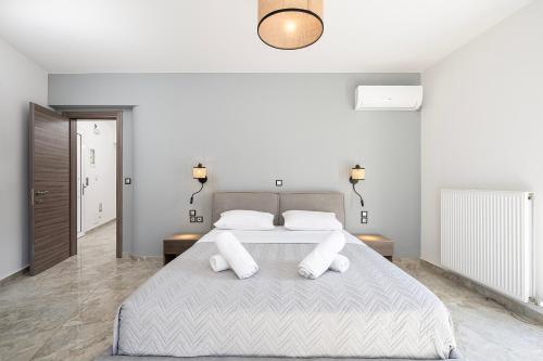 a bedroom with a large bed with two pillows at Sea, Sand n' Style La Bella's Port & Beach Retreat in Kos