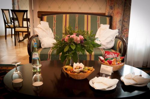 una mesa con dos cestas de fruta y una botella de vino en Hotel Schloss Schkopau en Schkopau