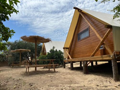 a log cabin with a table and umbrella at BOHO GLAMPING CONIL in Cádiz