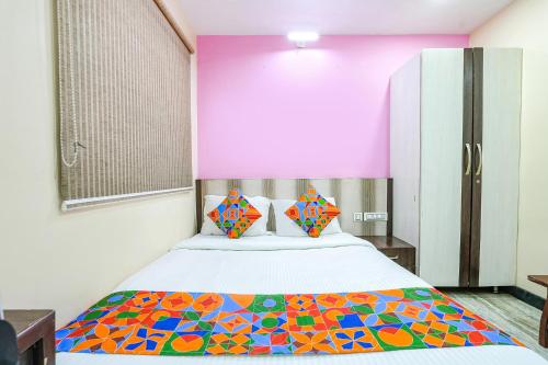 1 dormitorio con 1 cama con una manta colorida en FabExpress Raj Supreme Residency, en Chennai