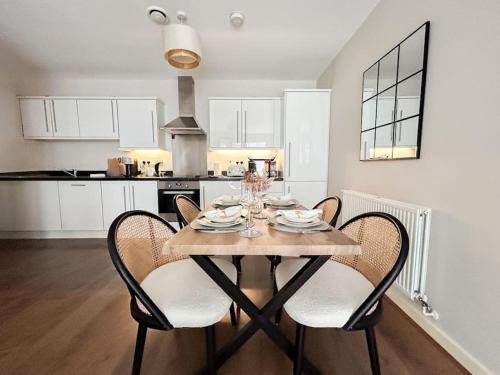 een eettafel met stoelen en een keuken bij Stylish Urban Sanctuary with Parking in Londen