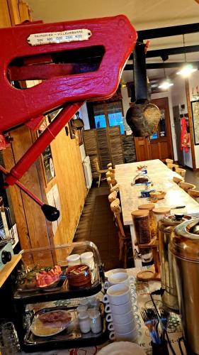 een keuken met een tafel met borden en een rode stoel bij La Fruitière d'Arith in Arith