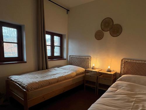 a room with two beds and two windows at Zbirožský dvůr in Zbiroh