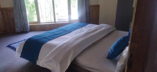 a large bed in a bedroom with a window at White House Leh in Leh