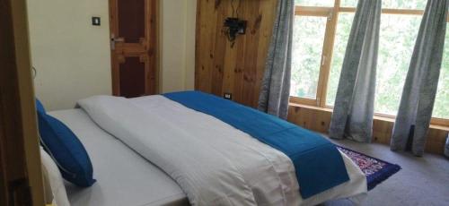 a bed sitting in a bedroom with a window at White House Leh in Leh