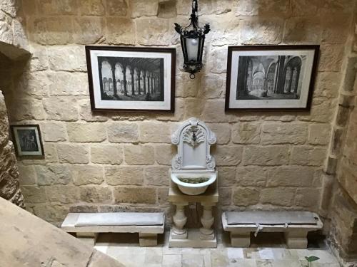 a stone wall with a sink and two pictures at Charming 17th Cent House of Character in the famous 3 Cities, right next to Valletta in Cospicua