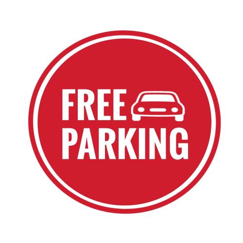 a red free parking sign with a car on it at California Lodge in Bagamoyo
