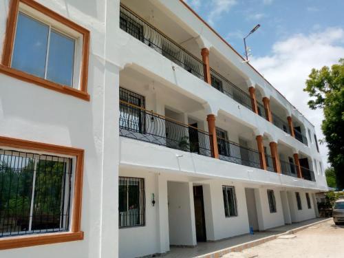 a white building with a balcony on the side at Stay with Adhiambo in Kilifi