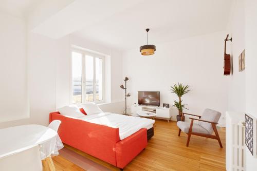 - une chambre blanche avec un canapé rouge et une télévision dans l'établissement Charme et confort entre jardin des plantes et LU, à Nantes