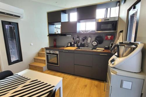 - une cuisine avec des appareils en noir et blanc dans l'établissement LOU BRISOU, à Croagnes