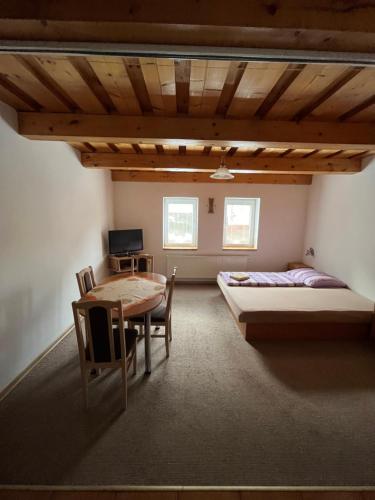 Habitación con 2 camas, mesa y escritorio. en Apartmány Bistár, en Zuberec
