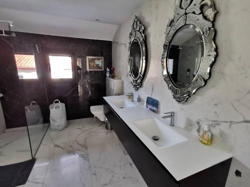 uma casa de banho com um lavatório e um espelho na parede em Ciboure, villa avec piscine 8 couchages quatre étoiles em Ciboure
