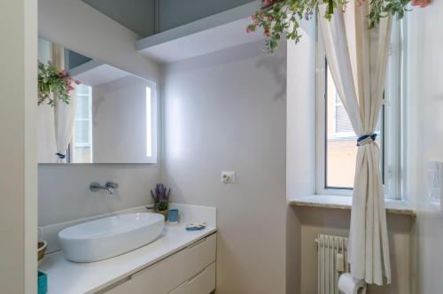 uma casa de banho branca com um lavatório e uma janela em Navona Charming Balcony em Roma