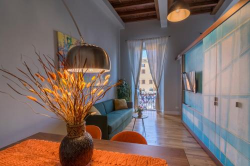 uma sala de estar com um sofá e uma mesa com um vaso em Navona Charming Balcony em Roma
