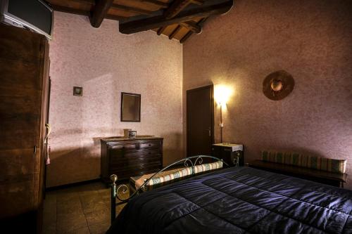 a bedroom with a bed and a dresser in it at Agriturismo il Poggetto in Torre