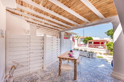 a patio with a wooden table and a wooden ceiling at Terrazza e Conchiglie in Torre Suda