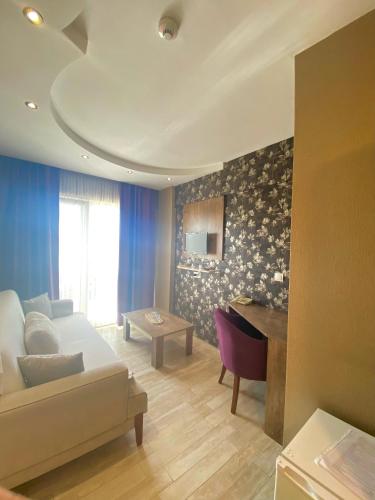 Una sala de estar con un sofá blanco y una mesa. en Udi Hotel, en Canakkale