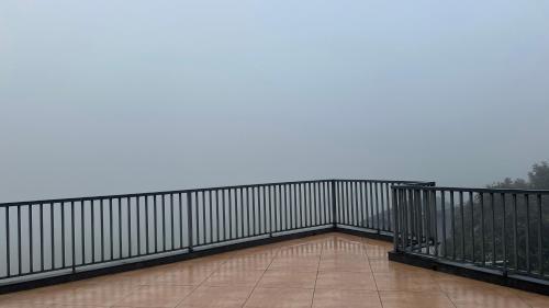a balcony with a black railing and a tile floor at Western Ghats Holiday Home in Kalpetta