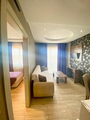 una sala de estar con un sofá y una cama en Udi Hotel, en Canakkale