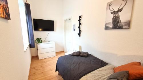 a bedroom with a deer picture on the wall at Modernes Apartment für 5 Personen in Schwerte