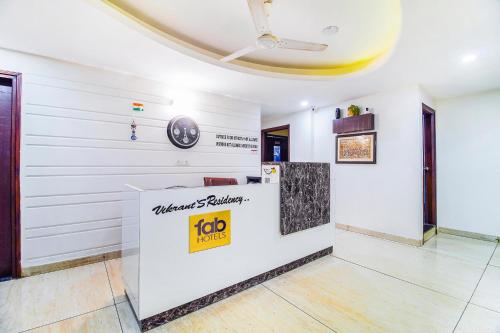 a lobby with a reception counter and a clock on the wall at FabHotel VR Stay in Gurgaon