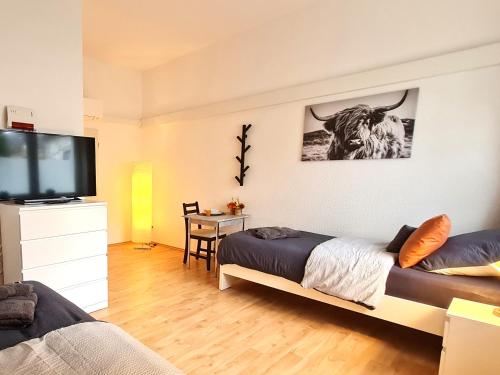 een slaapkamer met een bed en een flatscreen-tv bij Modernes Apartment für 5 Personen in Schwerte