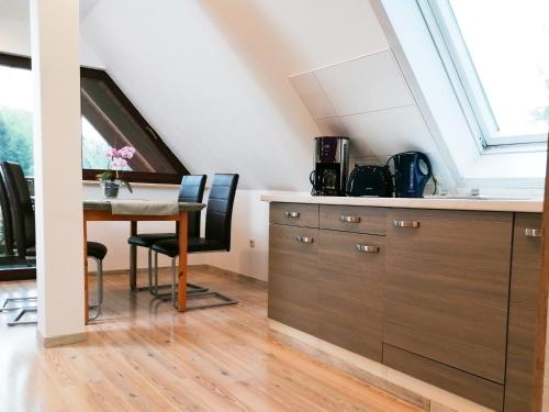 a kitchen with a desk and a table with chairs at Pension Pfefferstübchen in Brotterode-Trusetal