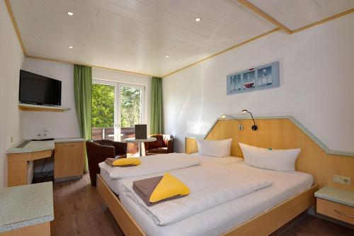 ein Schlafzimmer mit einem großen Bett und einem gelben Kissen in der Unterkunft Pension Pfefferstübchen in Brotterode
