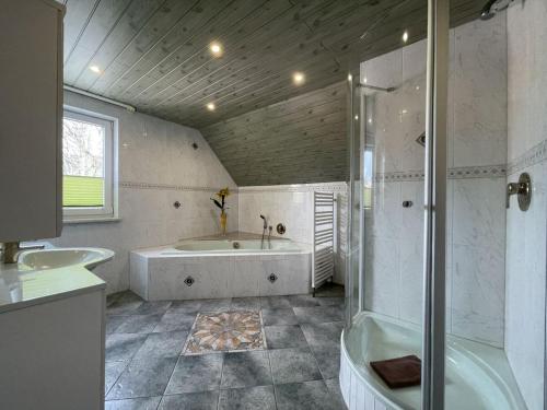 ein Bad mit einer Badewanne, einer Dusche und einem Waschbecken in der Unterkunft Pension Pfefferstübchen in Brotterode