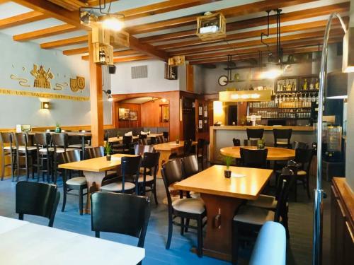 restauracja z drewnianymi stołami i krzesłami oraz bar w obiekcie Bischoffs Hotel w mieście Bad Urach