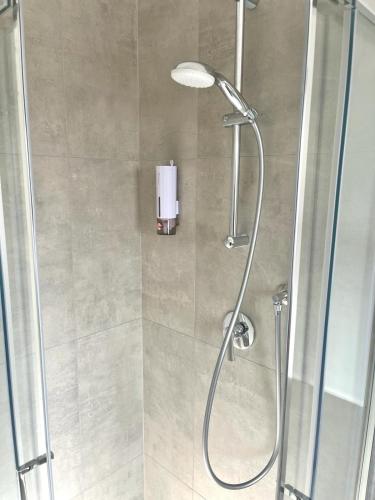 a shower with a glass door and a shower head at MaurusHome come a casa tua. in Fiumicino