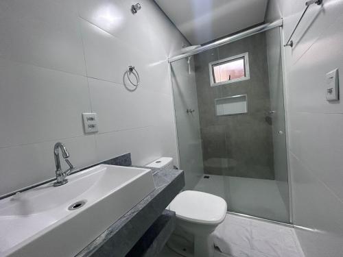La salle de bains est pourvue d'une douche, d'un lavabo et de toilettes. dans l'établissement Ouro Preto Suítes, à Ouro Preto