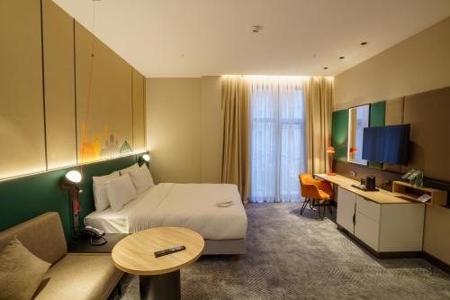 een hotelkamer met een bed en een bureau bij Holiday Inn Tashkent City, an IHG Hotel in Tasjkent
