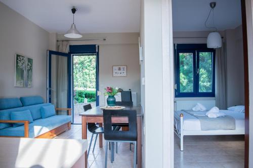 a living room with a blue couch and a bedroom at Villa Orama in Nea Potidaea