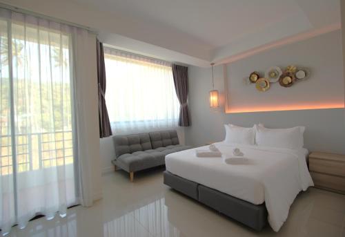 a bedroom with a large white bed and a couch at Kamala Havana in Kamala Beach